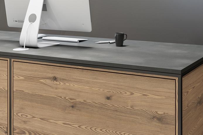 Detailaufnahme Schreibtisch aus Holz Detailaufnahme von Schreibtisch mit Computer Rückseite